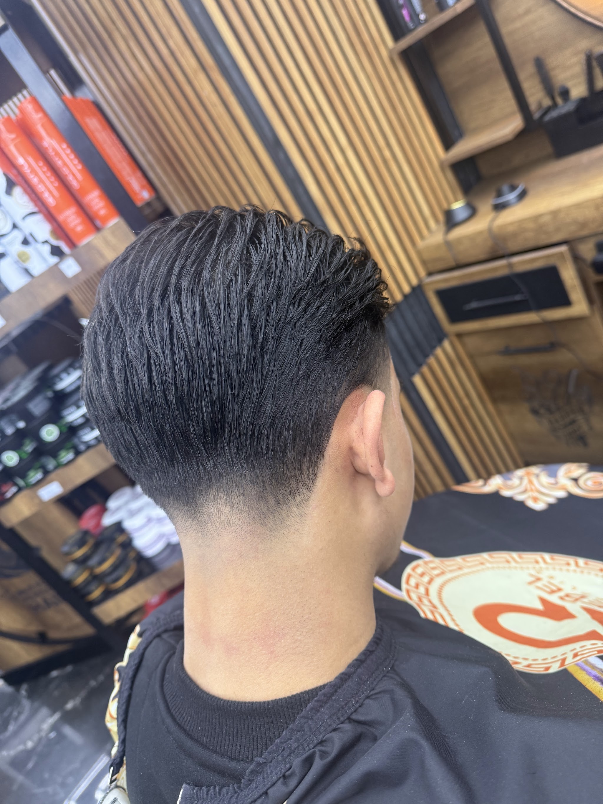 Een taper fade tegen de houten lattenwand in de zaak
