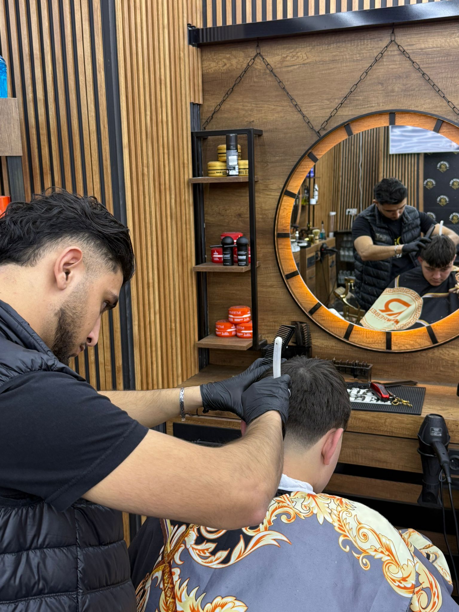 Een barbier zet met een open scheermes de nekrand